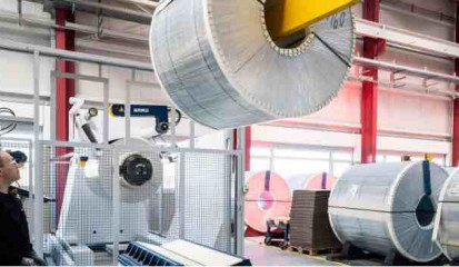 Die 34 Meter langen Laserblanking-Anlage von TRUMPF spart Rohmaterial und rund 4000 Tonnen CO2 pro Jahr.  Coil_einlegen Maschinenbediener Martin Müller hievt ein 16-Tonnen-schweres Alu-Coil in die Beladezone der TruLaser 8000 Coil Edition von TRUMPF.